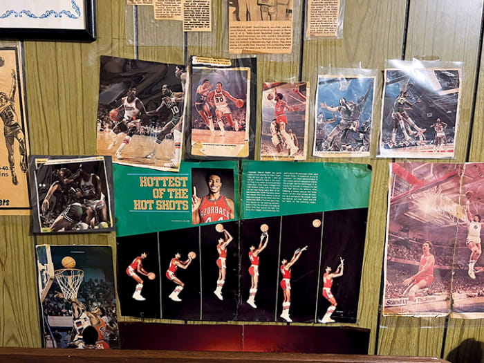 Former Arkansas assistant coach Matt Zimmerman's childhood wall featuring several basketball articles and a spread of former Razorback basketball star Marvin Delph.